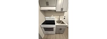 A modern kitchen with a stove top oven and a sink.