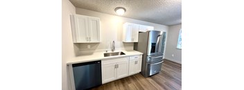2-bedroom kitchen at Bridgeport Terrace Apartments with white cabinets, white quartz countertops, and stainless steel appliances
