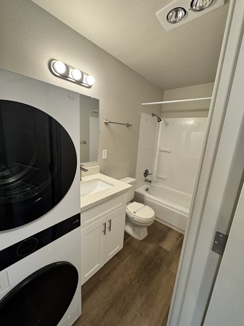 2-bedroom bathroom with a white & black washing machine and dryer and a shower & tub combination at Bridgeport Terrace Apartments