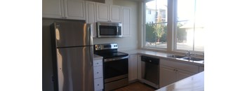 A kitchen with a stainless steel refrigerator, microwave, oven, and dishwasher.