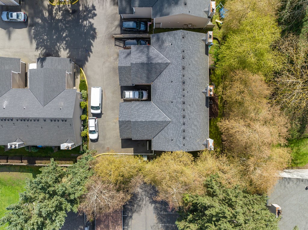 A bird's eye view of a residential area with houses and parked cars.