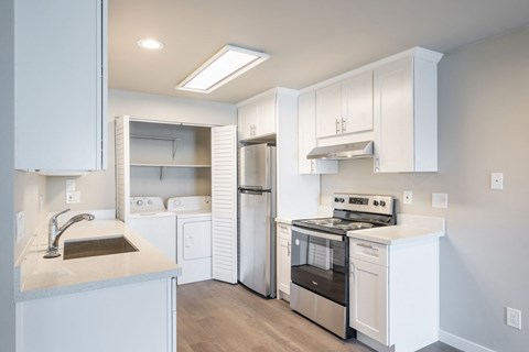 A kitchen with white cabinets and stainless steel appliances.
