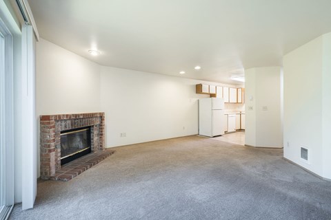 A living room with a fireplace and a carpet.