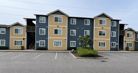 A parking lot in front of a row of townhouses.