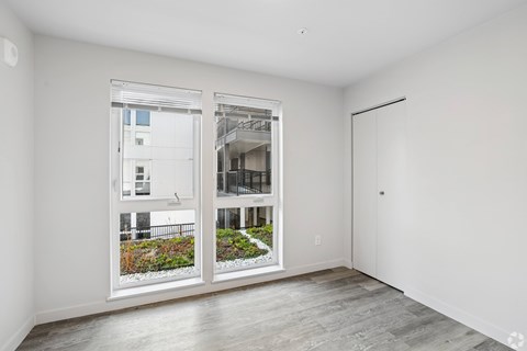A room with a view of a building through the window.