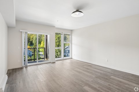 A spacious room with a sliding glass door leading to a backyard.