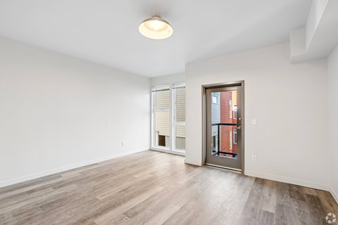 A room with a sliding glass door and a wooden floor.