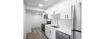 A modern kitchen with white cabinets and stainless steel appliances.