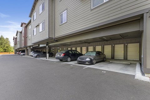 A parking lot with cars parked in front of a building.