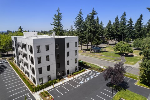 A large white building with a parking lot in front of it.