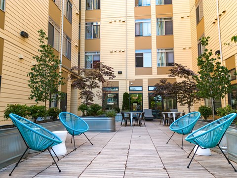 Bode125's community courtyard with  seating, tables, and foliage