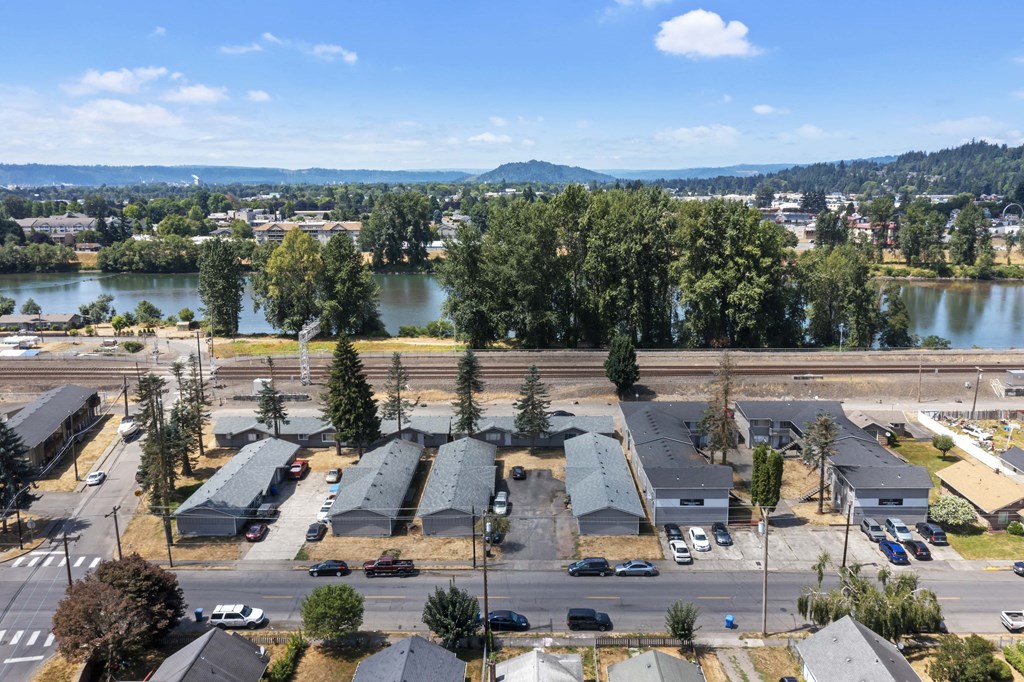 an aerial view of a city with a river and mountains in the background