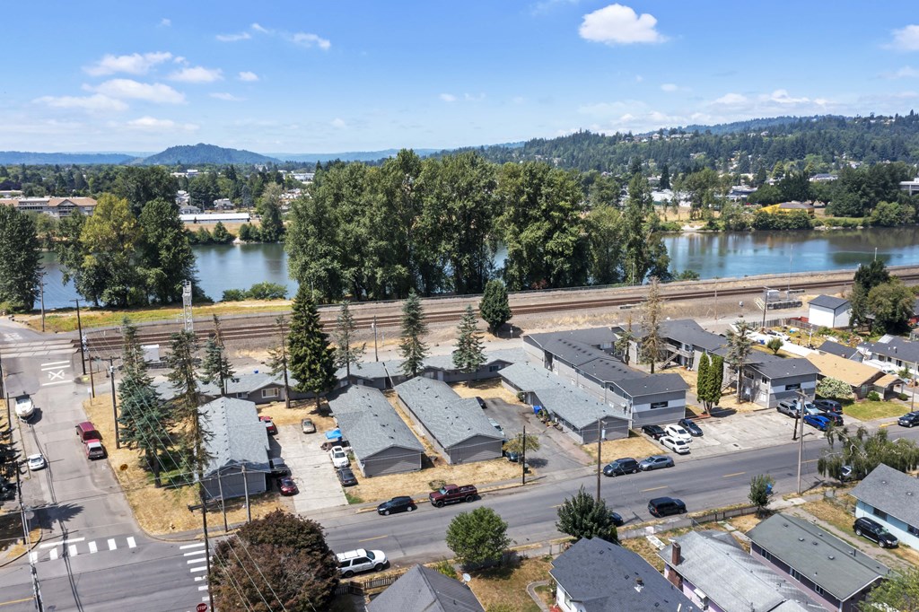 an aerial view of a subdivision with a river and mountains in the background