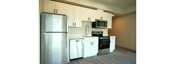 A kitchen with white cabinets and appliances.