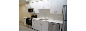 A kitchen with white cabinets and stainless steel appliances.