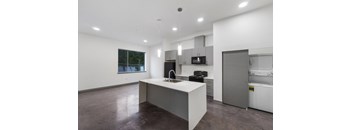 a kitchen with white cabinets and a white island with a sink