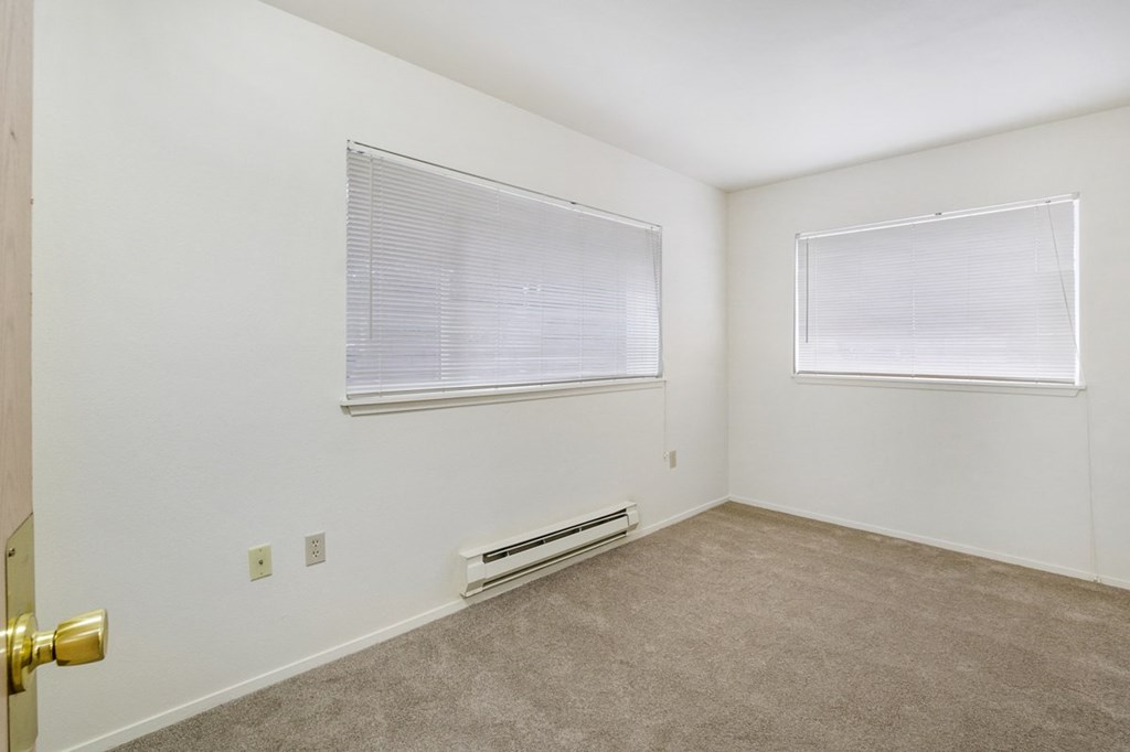 an empty room with a window and a door