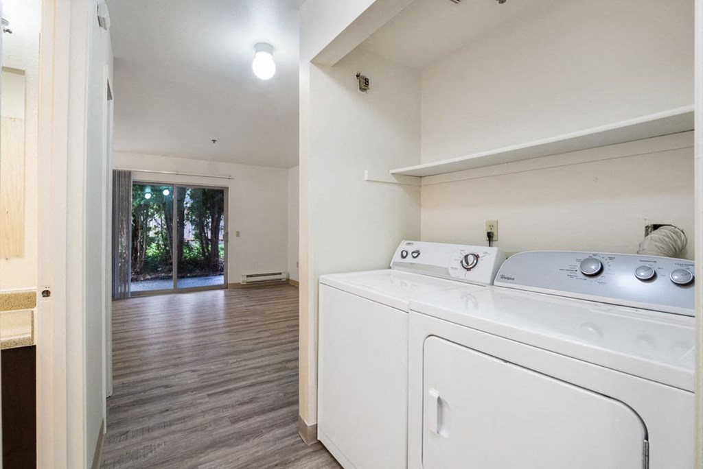 a washer and dryer in a room with a door to a living room