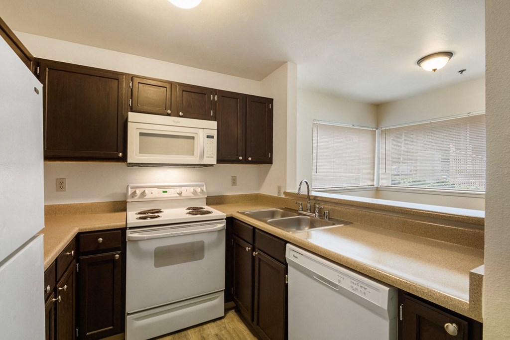 the preserve at ballantyne commons apartment kitchen with white appliances and dark cabinets
