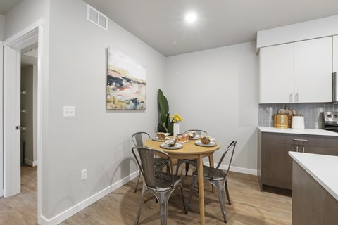 A dining room with a table set for four.