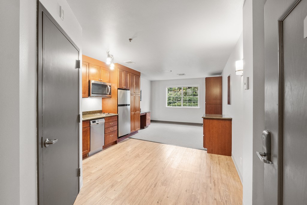 an empty kitchen with wood floors and stainless steel appliances