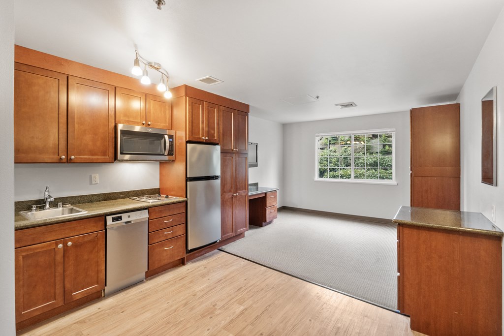 an empty kitchen with wooden cabinets and stainless steel appliances