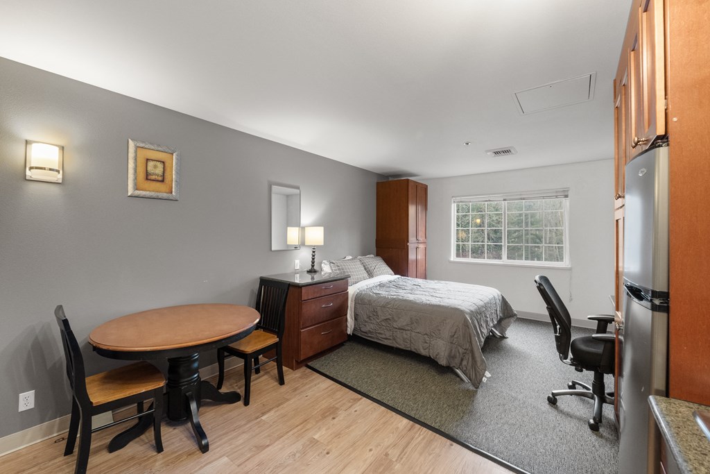 a bedroom with a bed and a desk and a table