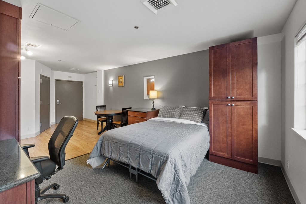 a bedroom with a bed and a desk and a chair