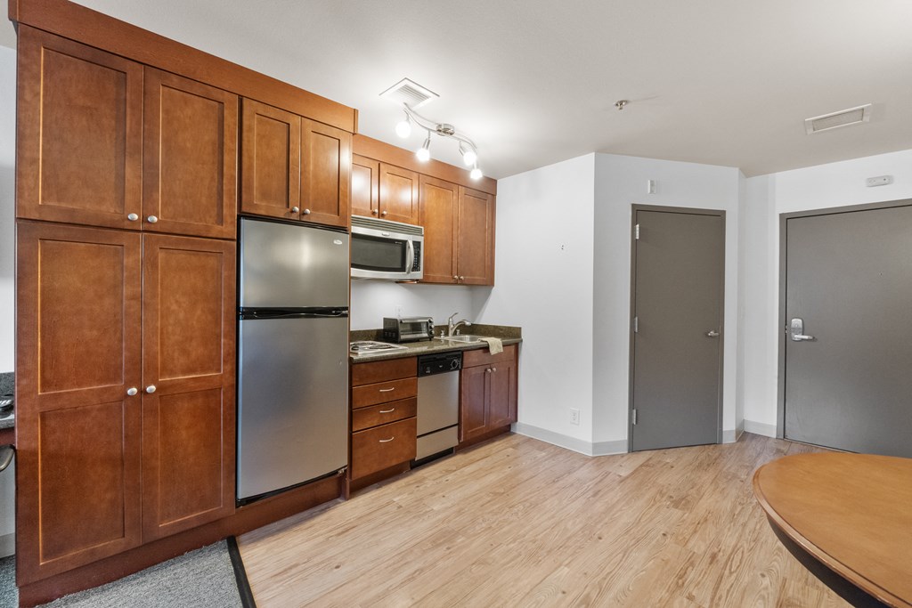 a kitchen with wooden cabinets and stainless steel appliances and a wooden table