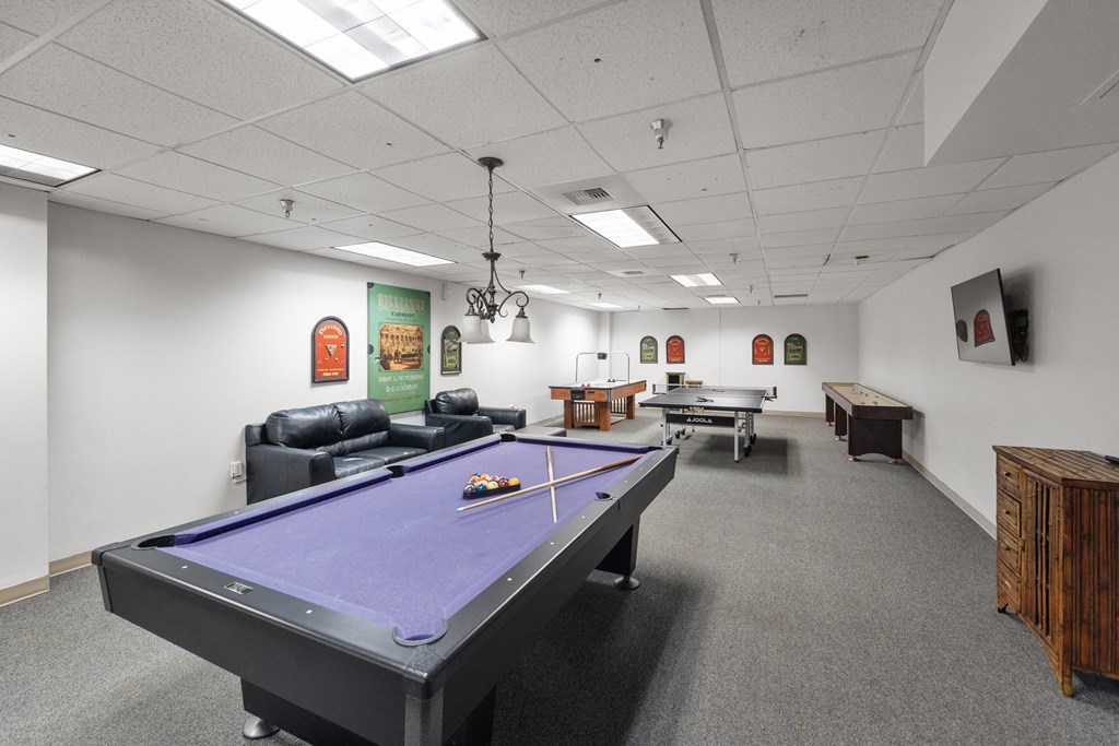 a game room with a pool table and two billiards tables