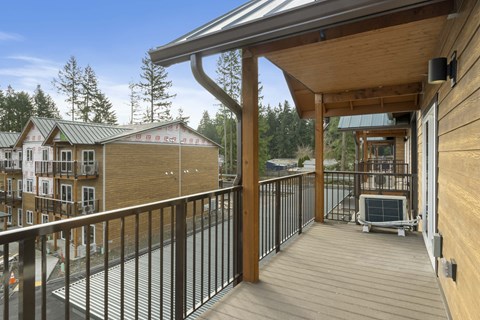A wooden deck with a metal railing and a hot tub.