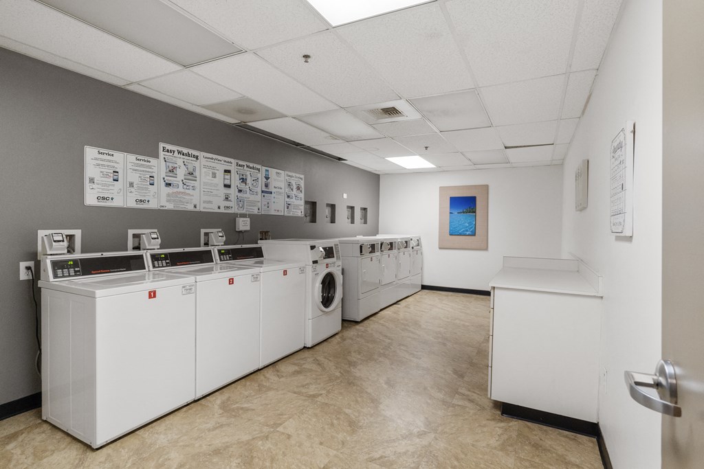 a laundry room with washers and dryers and a wall of papers and posters