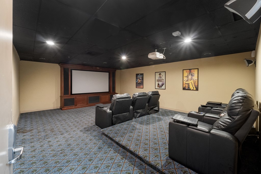 a large screening room with leather seats and a projector screen