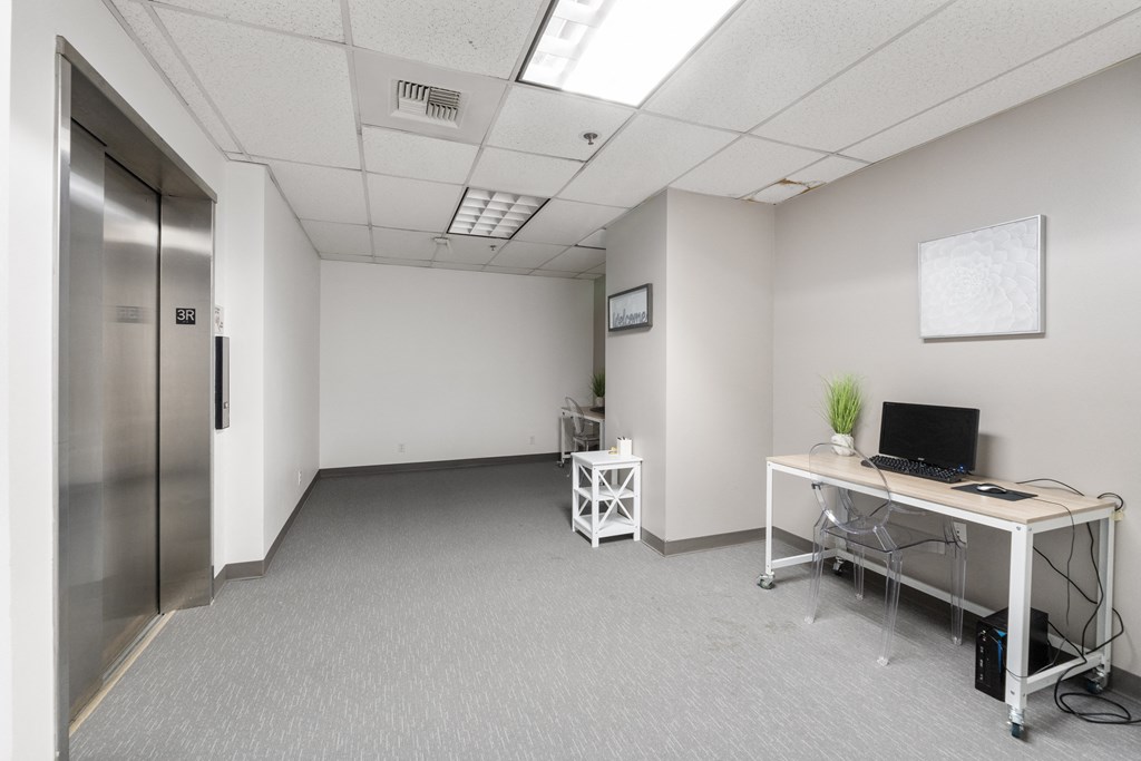 an empty room with a desk and a computer in it