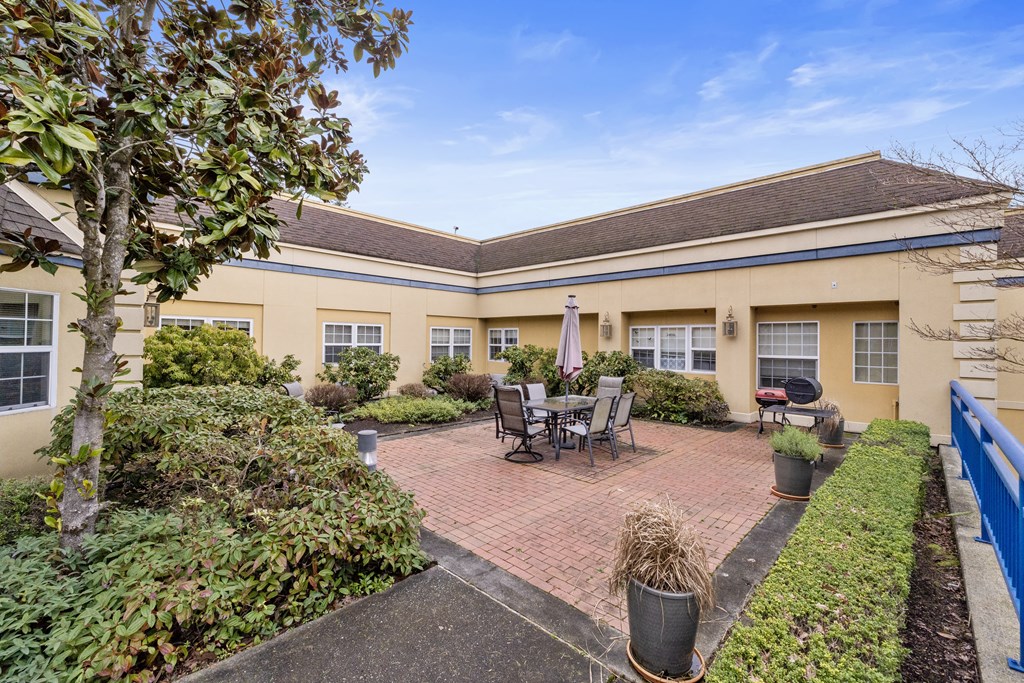 a patio with a table and chairs in front of a building