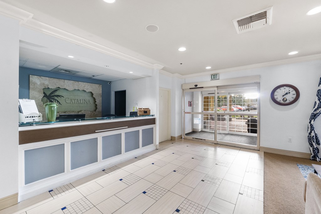a reception area with a counter and a glass door
