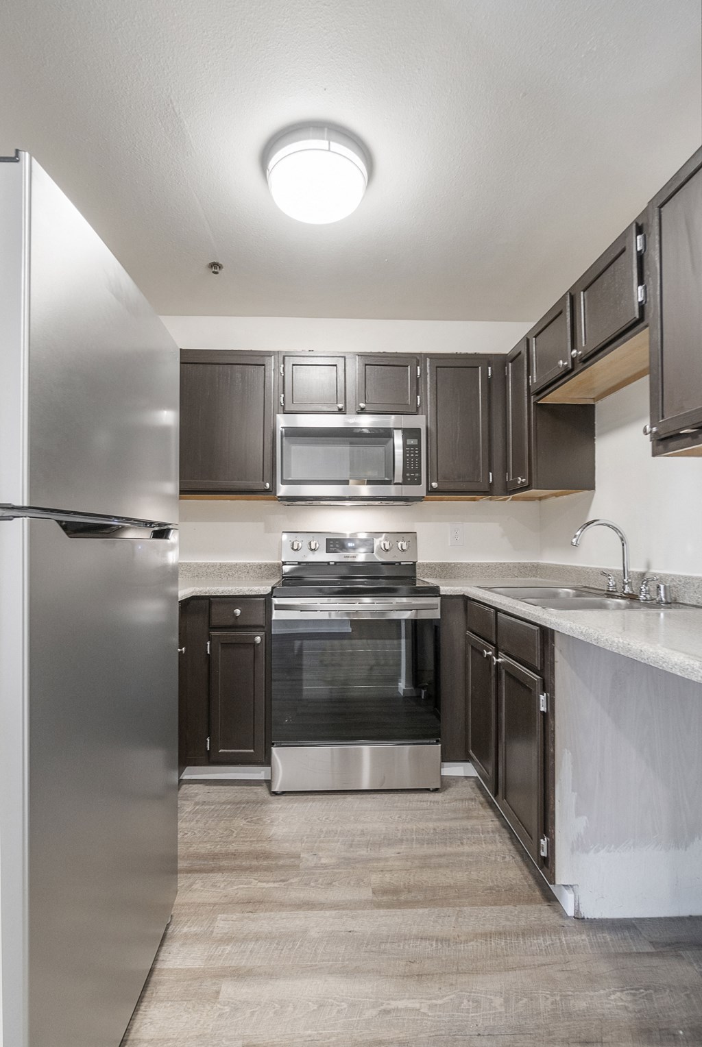 an empty kitchen with stainless steel appliances and marble counter tops
