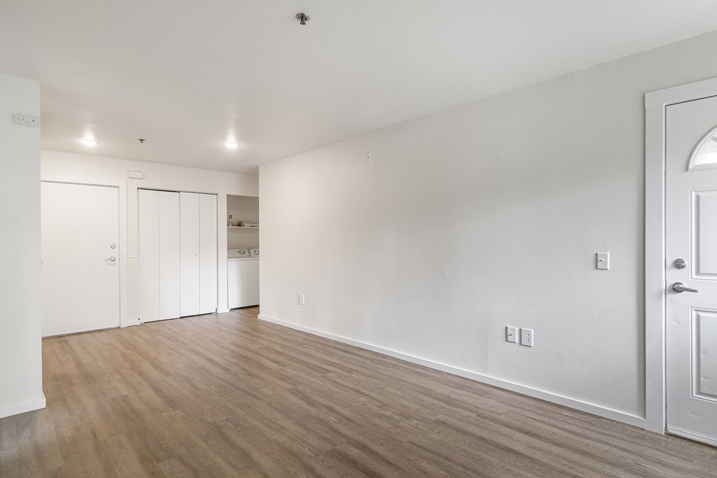 an empty living room with white walls and wood flooring