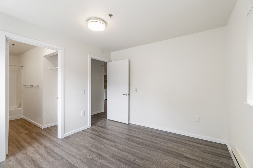an empty living room with white walls and wood flooring