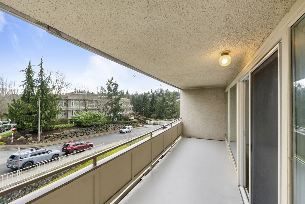 a balcony with a view of the street and cars on the road