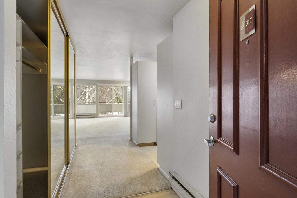 a hallway with a door open to a room with a view of a living room