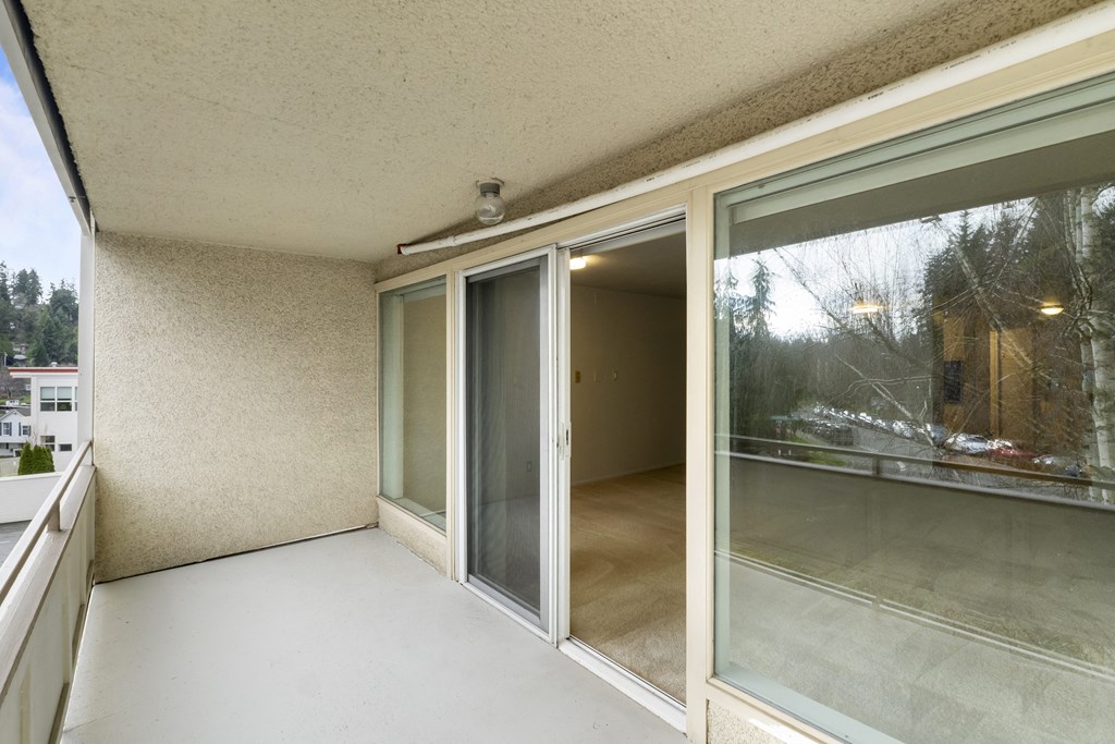 the living room of a condo with sliding glass doors and a patio