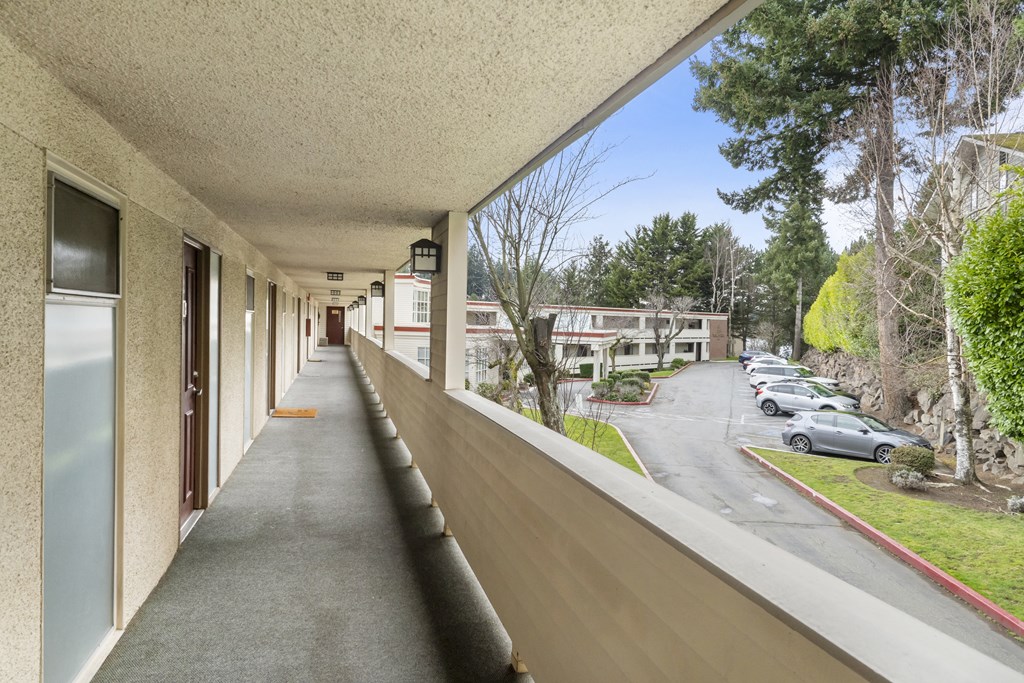 a long balcony with a view of a parking lot