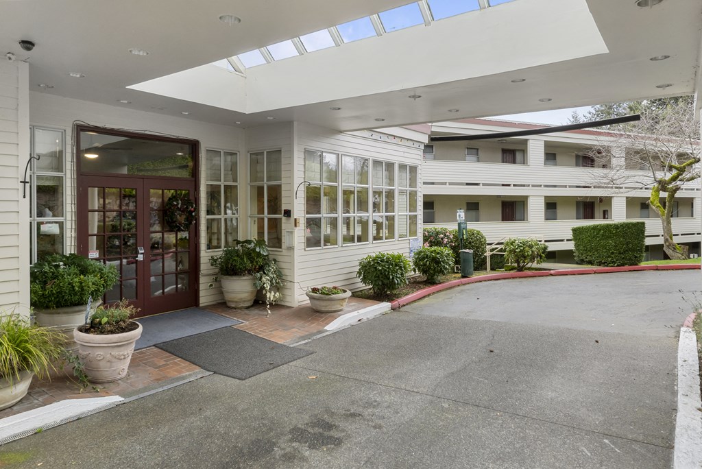 the entrance of a building with a driveway and a red door