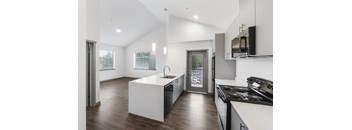 a kitchen with white walls and a wooden floor