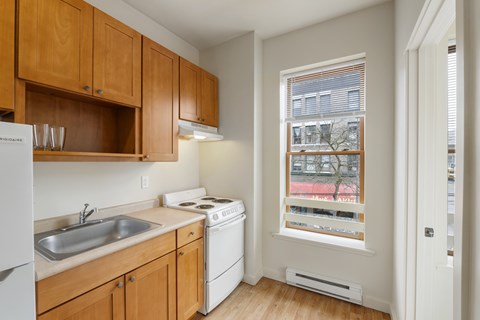 A kitchen with wooden cabinets and a white fridge.