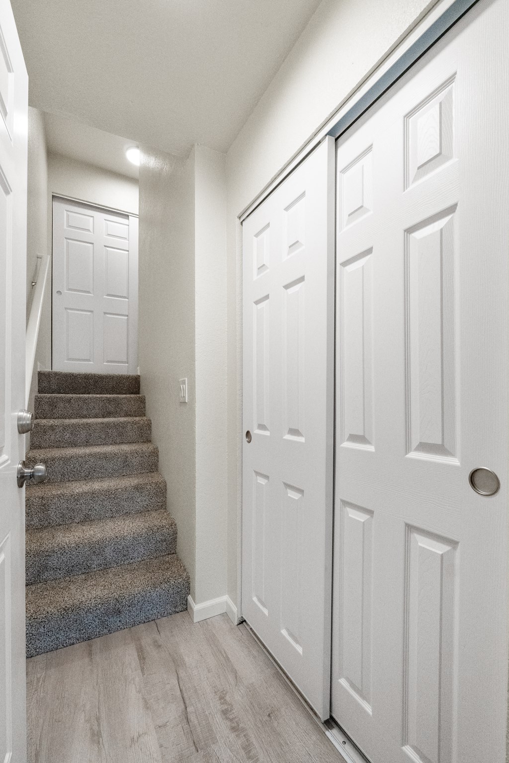 the landing of a staircase in a home with white doors and stairs