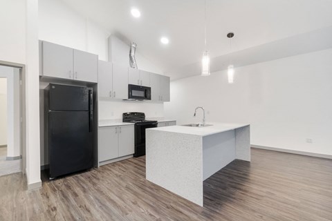 a kitchen with white cabinets and a black refrigerator