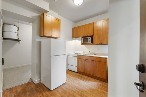 A kitchen with wooden cabinets and white appliances.