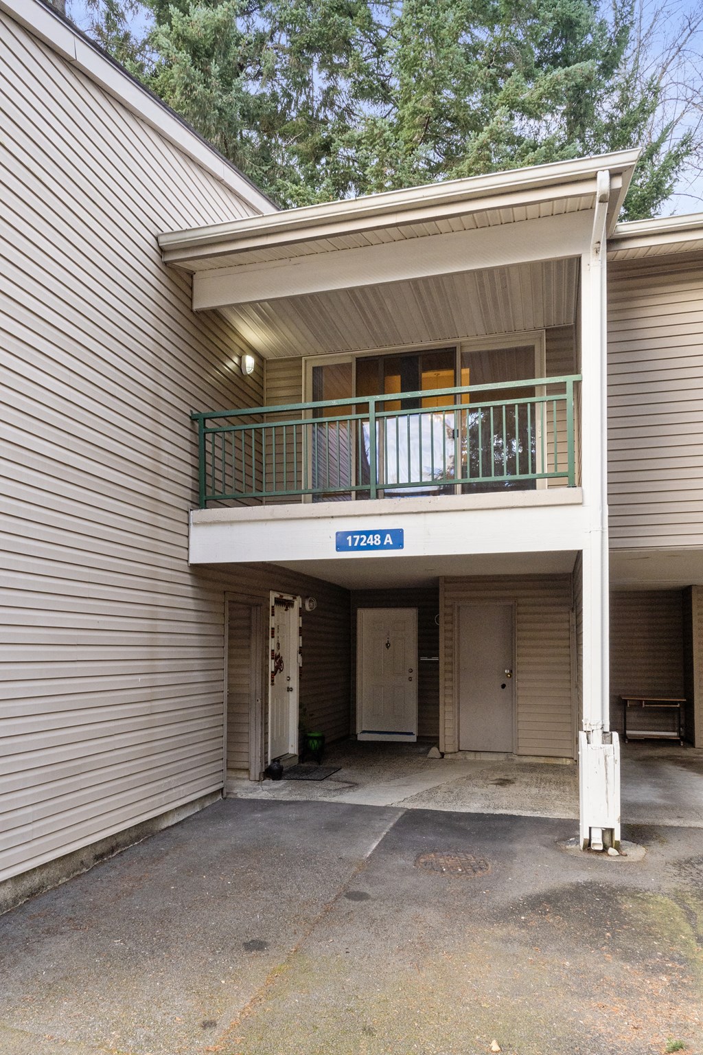 the front of a house with a balcony and a parking lot
